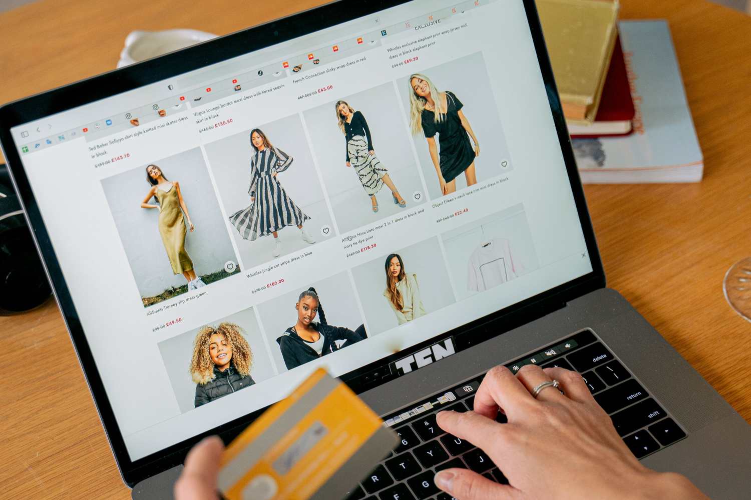 A person shopping for fashion on a laptop, browsing an online store