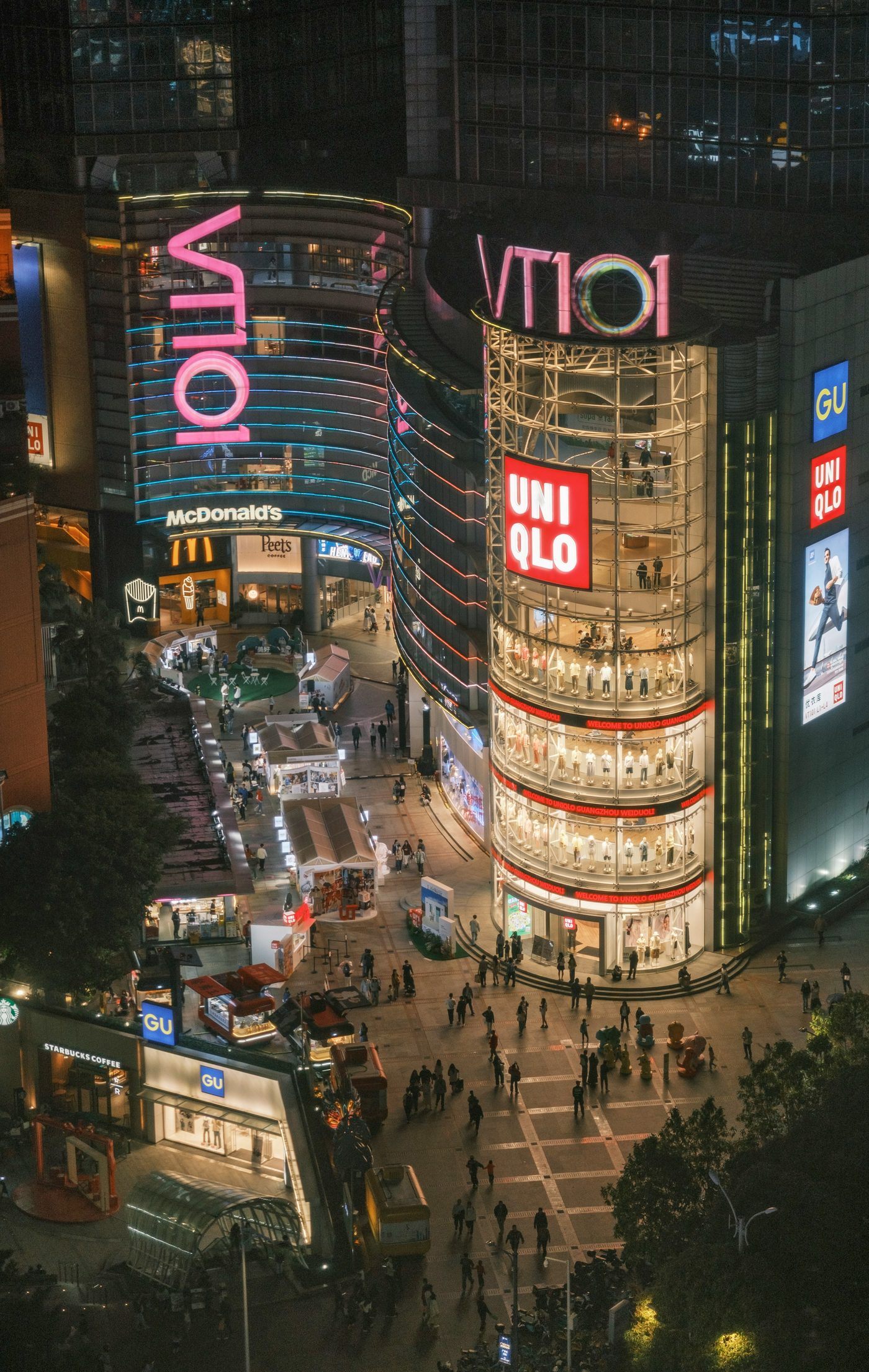 A busy street of illuminated shops at night